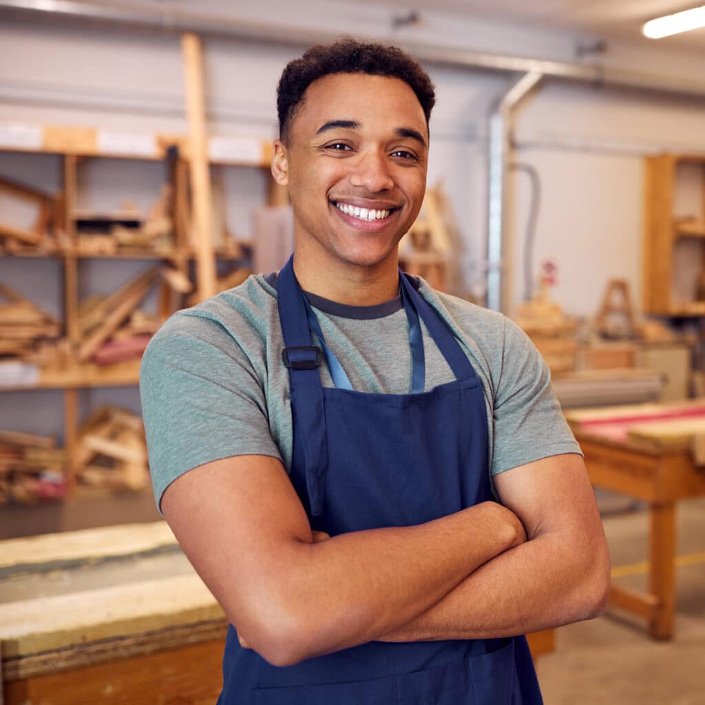 Young African American man standing in woodworking shop